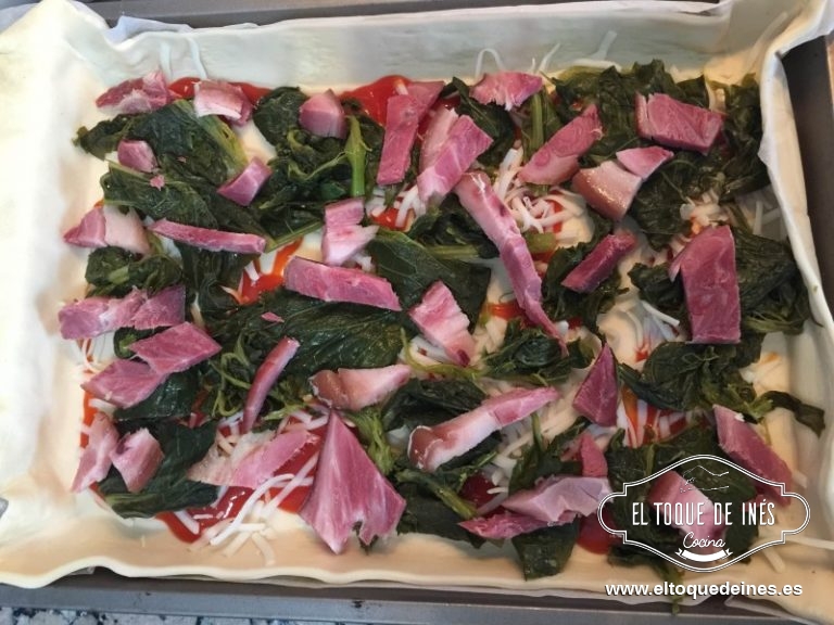 Extender encima la mozzarella, repartimos  los grelos encima y repartir el lacón cortado en trocitos .